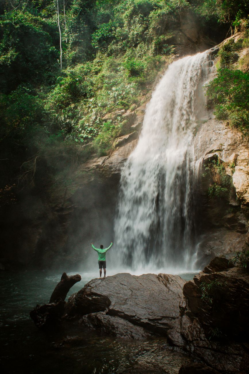 Turista desfrutando de cachoeira tropical